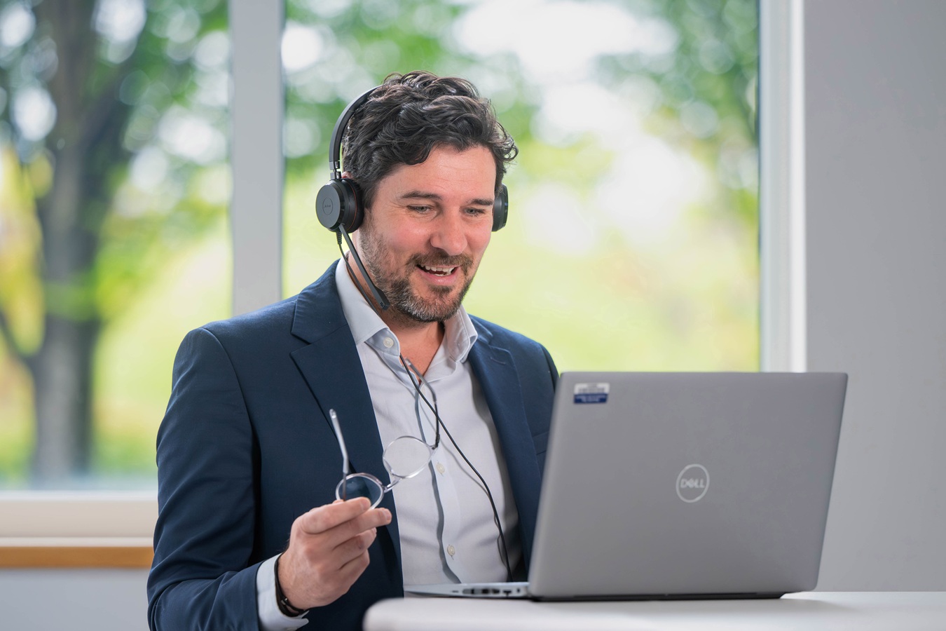 A man chatting on a headset, completing a customer audit