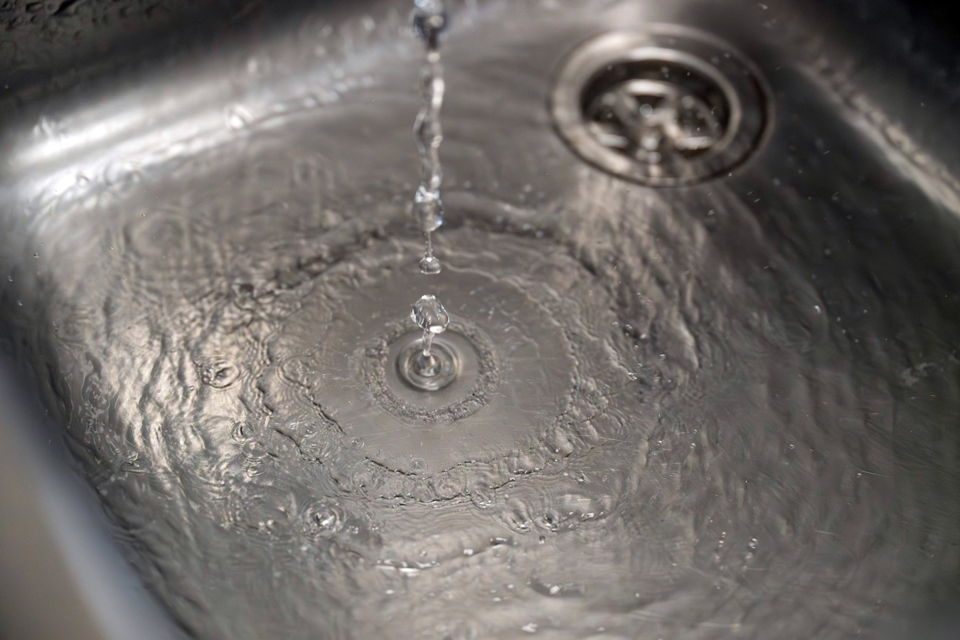 Water drops landing in a metallic sink