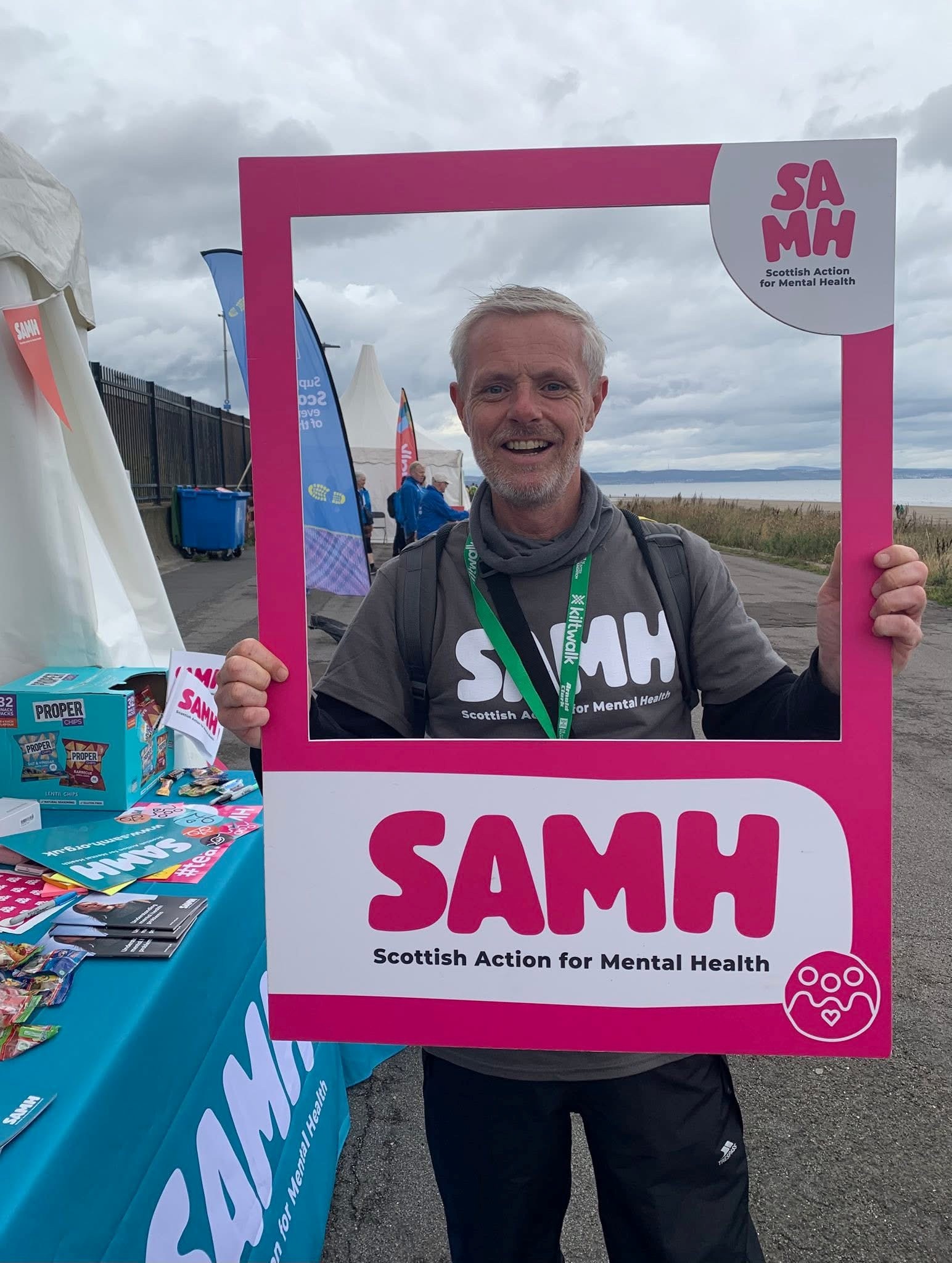 Business Stream Colleague smiling through a SAMH photo frame at a charity event