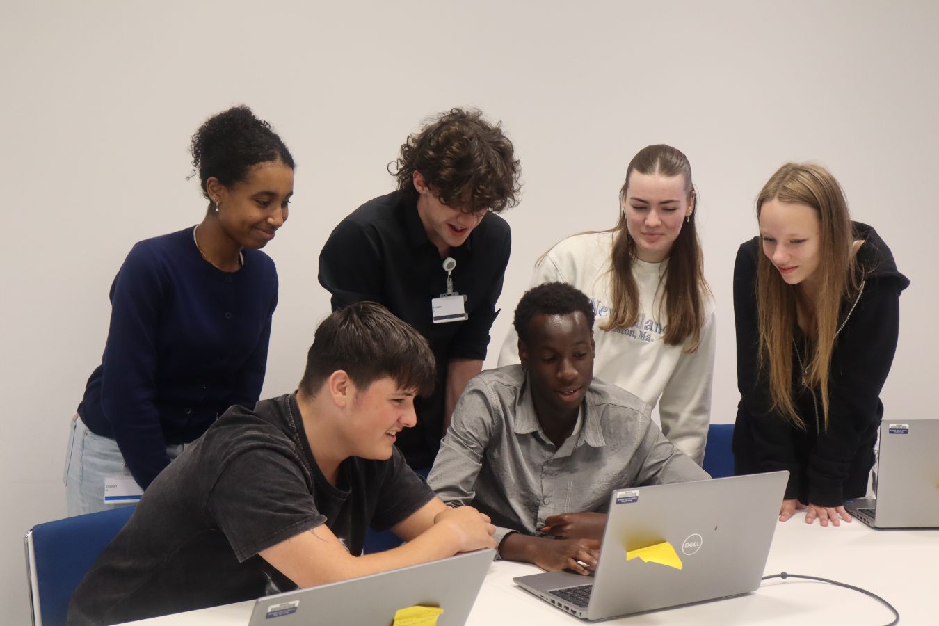 Six young people looking at laptop