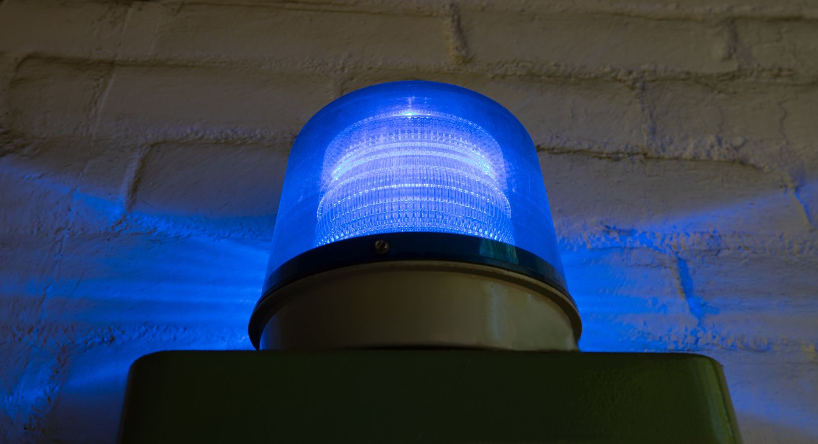 Flashing blue light mounted on a brick wall