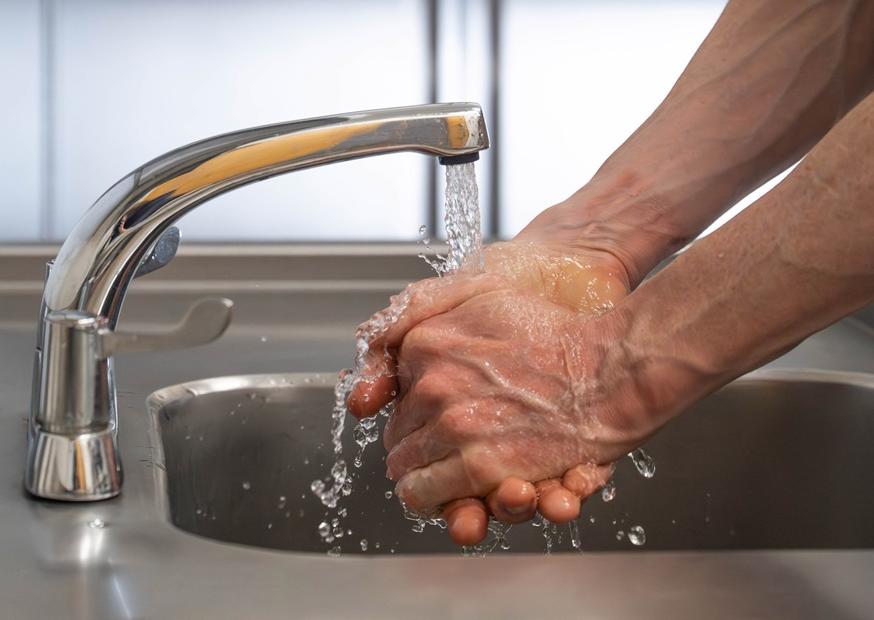A man's hands under a running tap