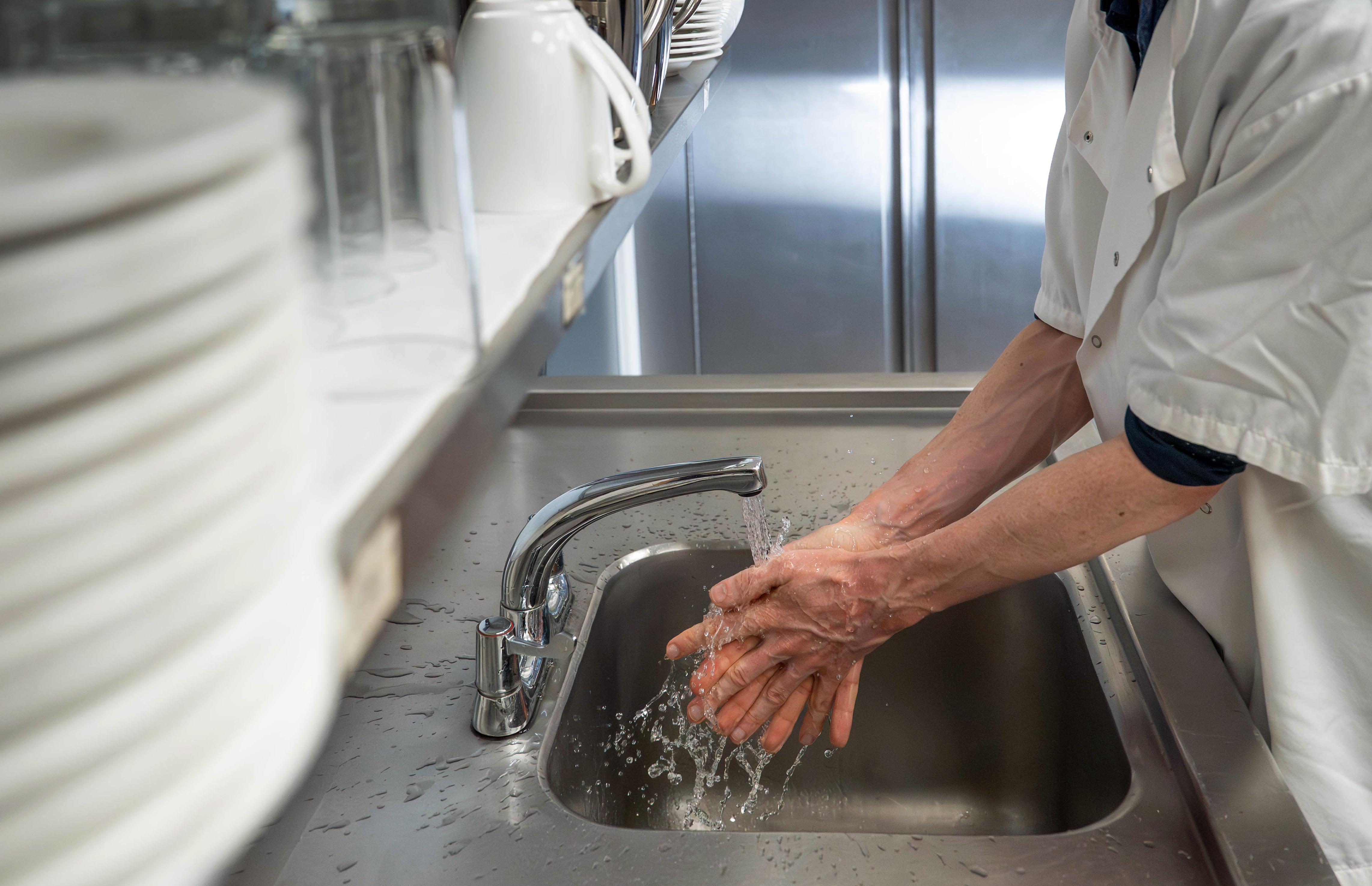 Man washing hands at commercial kitchen sink