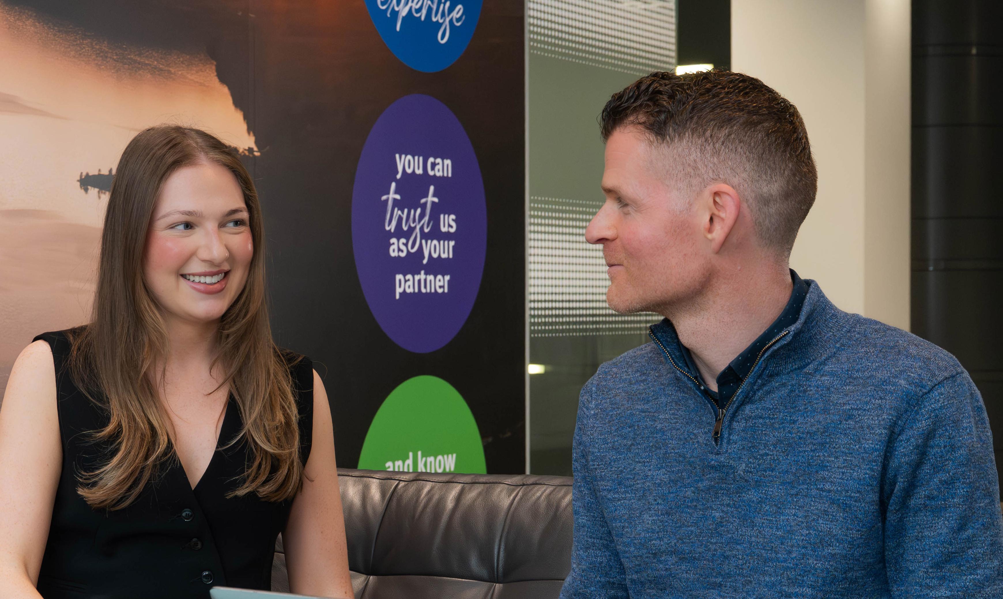 Woman and man sitting on sofa talking and smiling