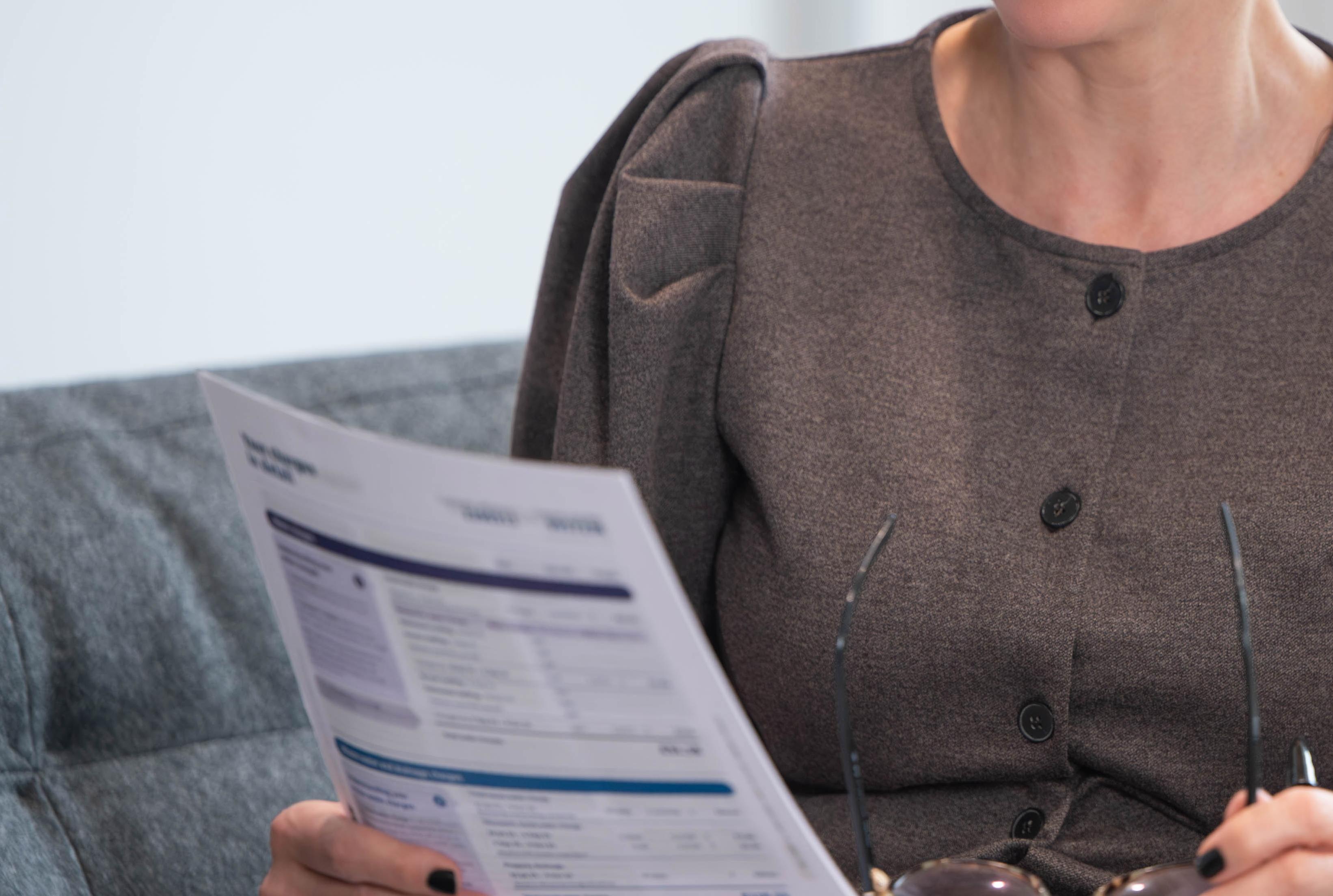 Close up of woman holding bill, face not in shot