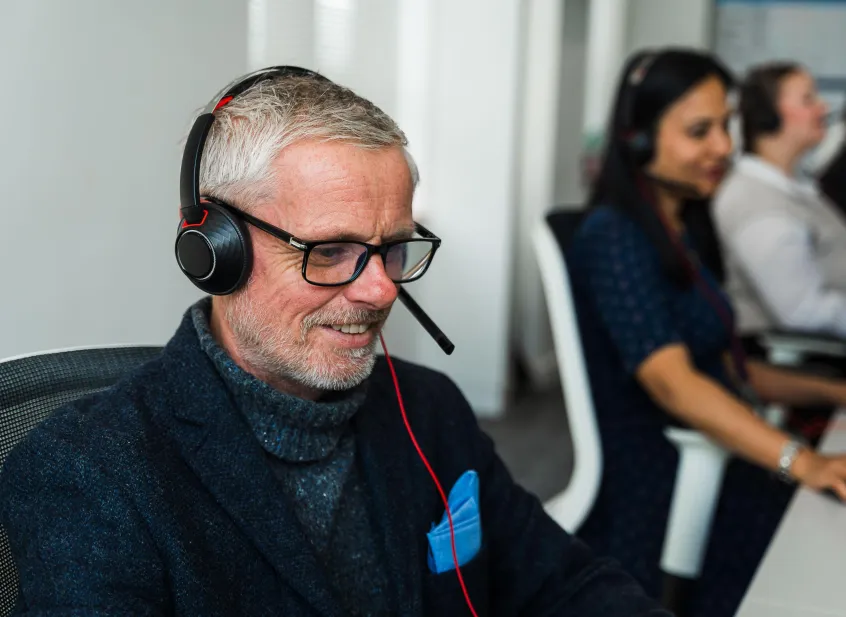 Man wearing headphones in call centre setting