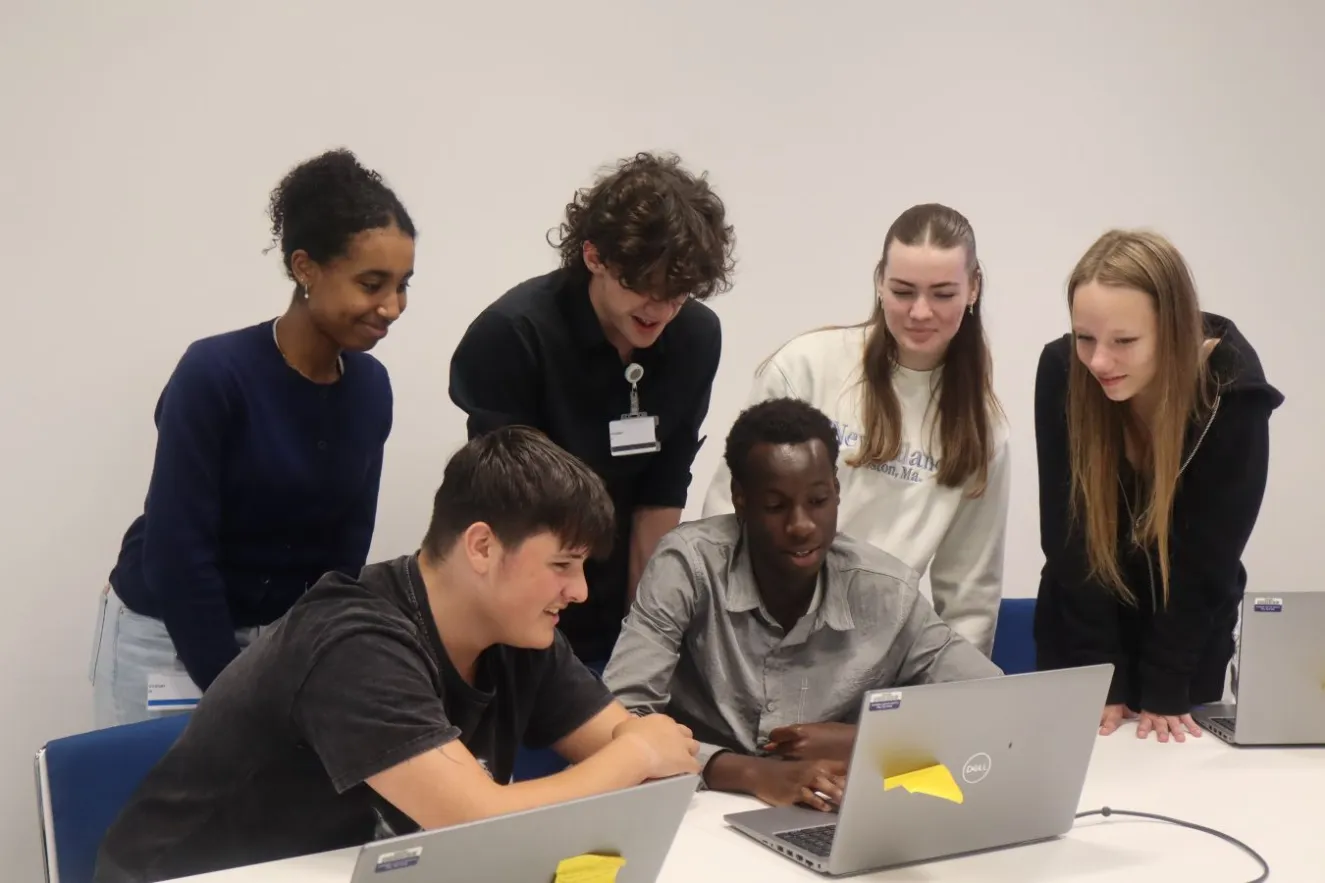 Six young people looking at laptop