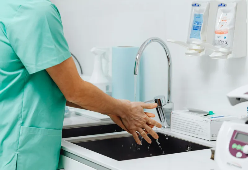 Medical person washing hands in sink
