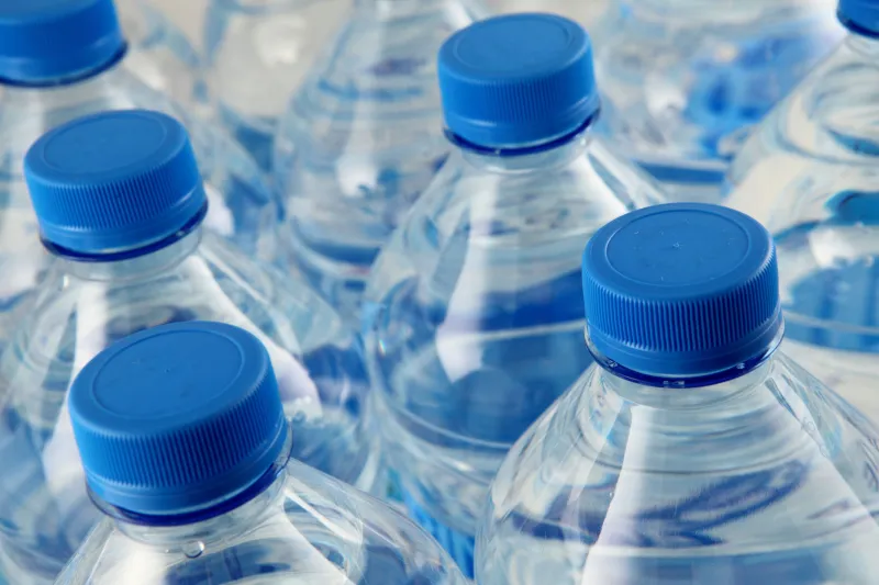 Close-up of bottled water with blue bottle tops
