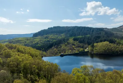 Glen Finglas reservoir in foreground with hills and forest in background.